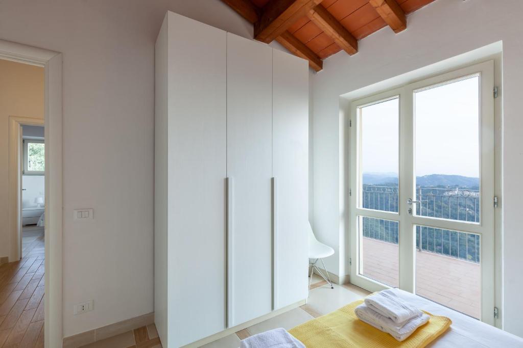 Cette chambre dispose d'armoires blanches et d'une grande fenêtre. dans l'établissement Villa Martina, à Pietrasanta