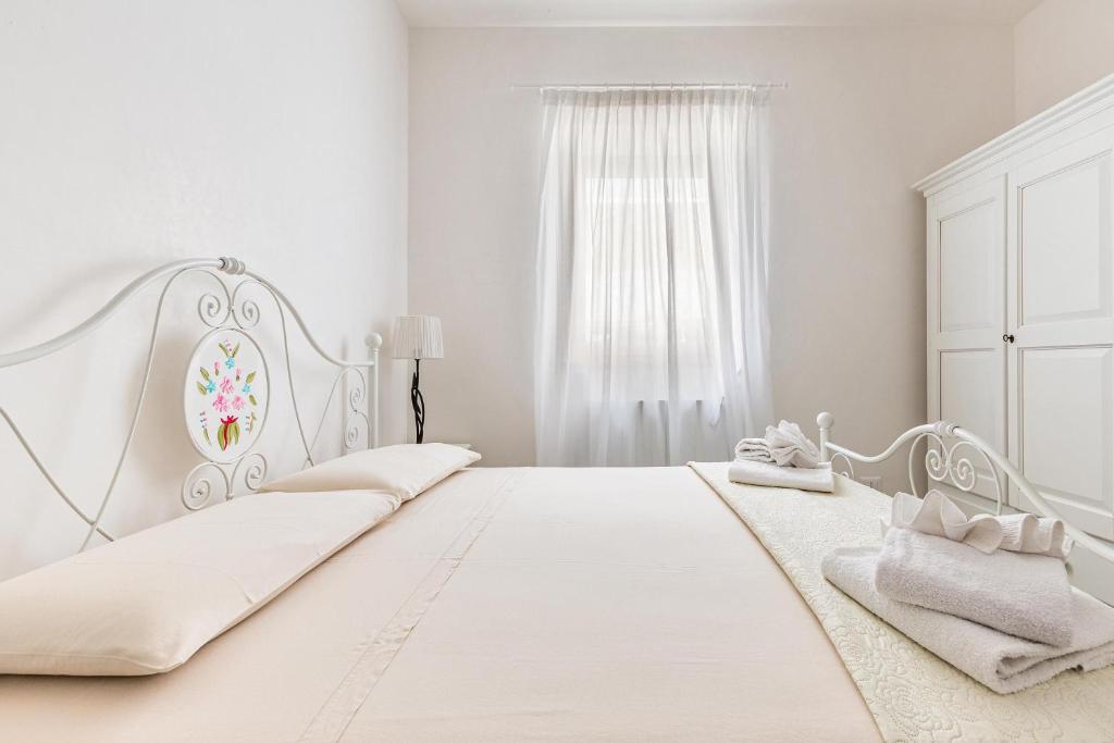 une chambre blanche avec deux lits et une fenêtre dans l'établissement Villa Theros by Perle di Puglia, à San Michele Salentino 36 autres photos