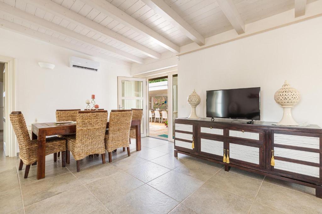 d'une salle à manger avec une table et une télévision à écran plat. dans l'établissement Villa Theros by Perle di Puglia, à San Michele Salentino