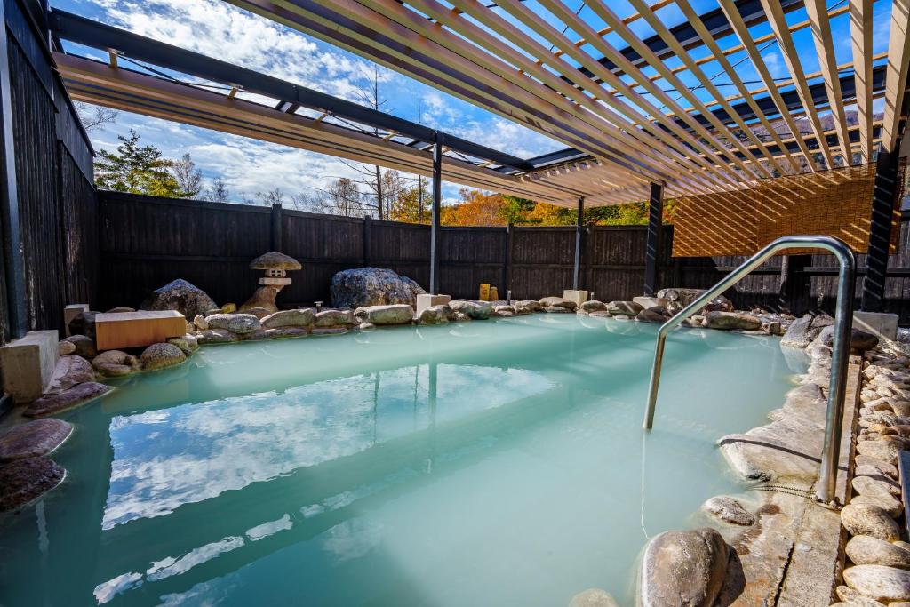 une piscine d'eau avec un plafond en bois dans l'établissement KAMENOI HOTEL Okunikko, à Nikkō