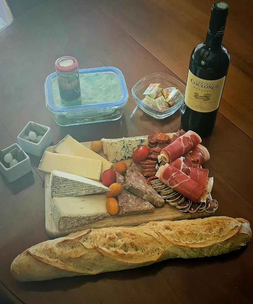 - une table avec une bouteille de vin et une assiette de nourriture dans l'établissement La Bulle du Cheix, à Saint-Diéry 12 autres photos
