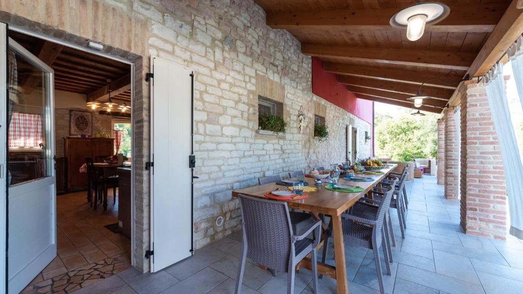 une salle à manger avec une longue table et des chaises dans l'établissement CASCINA MARIANNA 12&4, Emma Villas, à Fossombrone