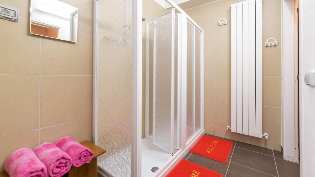 une salle de bain avec une douche avec des serviettes roses sur un banc dans l'établissement CASCINA MARIANNA 12&4, Emma Villas, à Fossombrone