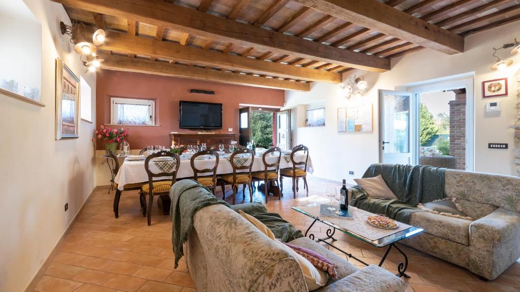un salon avec un long canapé et une salle à manger dans l'établissement CASCINA MARIANNA 12&4, Emma Villas, à Fossombrone
