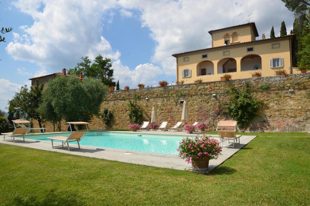 une maison avec piscine devant un immeuble dans l'établissement Favolosa Villa in Toscana, à Lucignano