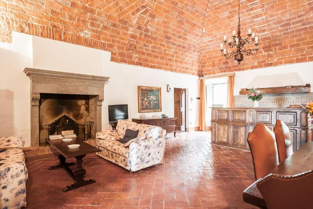 un salon avec un canapé et une cheminée dans l'établissement Favolosa Villa in Toscana, à Lucignano