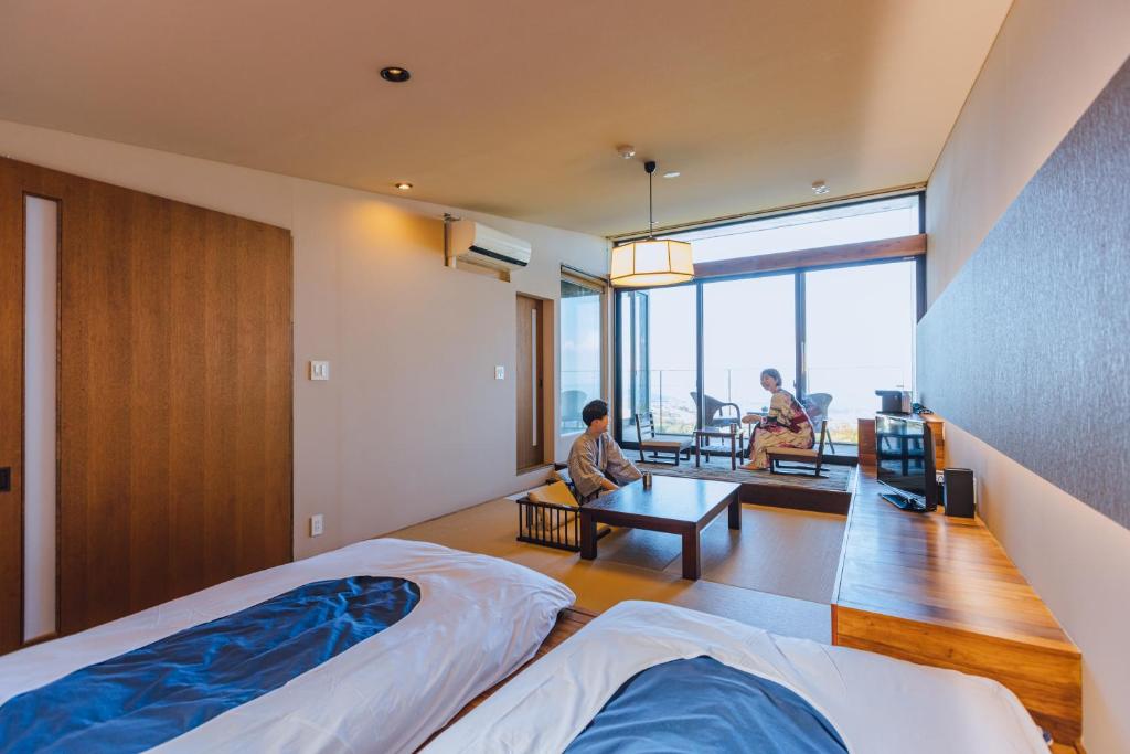 - une chambre avec 2 lits et des chaises dans l'établissement SEKIYA RESORT Terrace Midoubaru, à Beppu