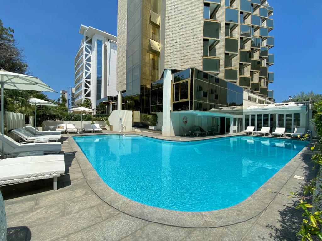 une grande piscine devant un immeuble dans l'établissement Hotel Ambasciatori, à Rimini