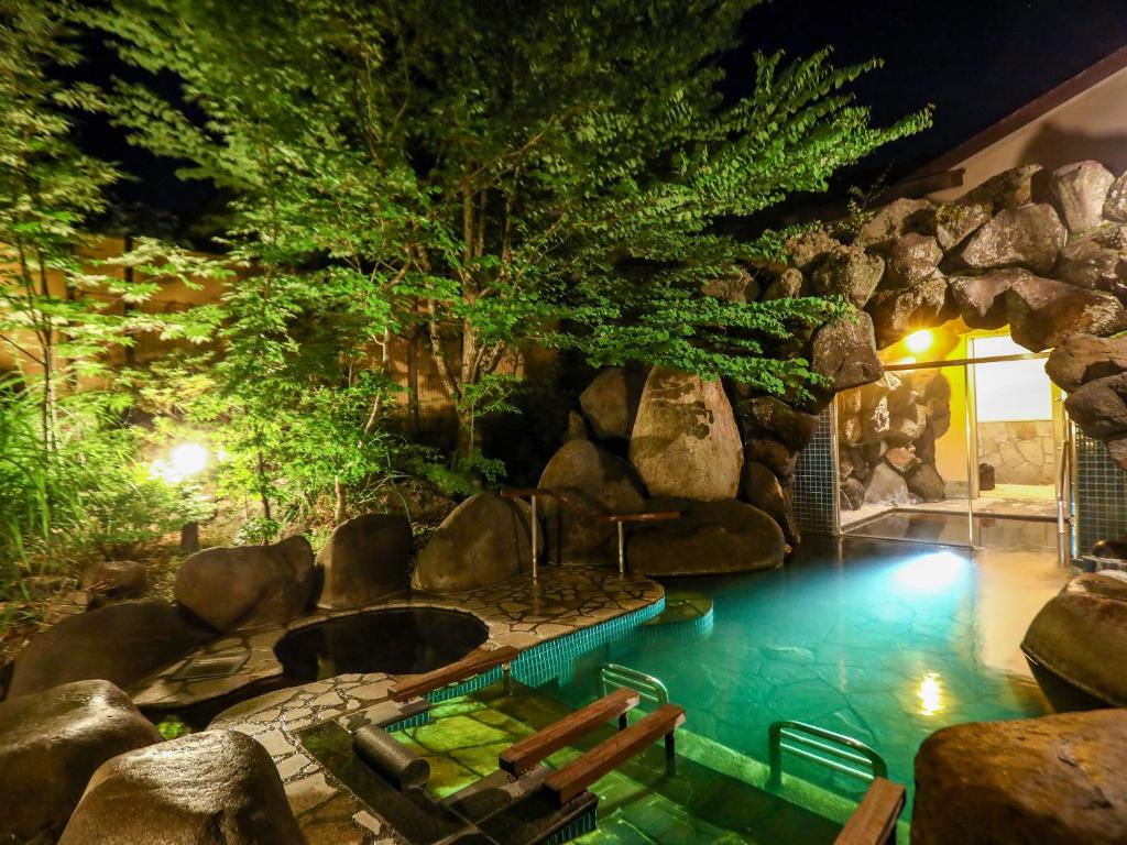- une piscine au milieu d'un complexe avec un mur de roche dans l'établissement Keiryuso Siorie, à Matsumoto