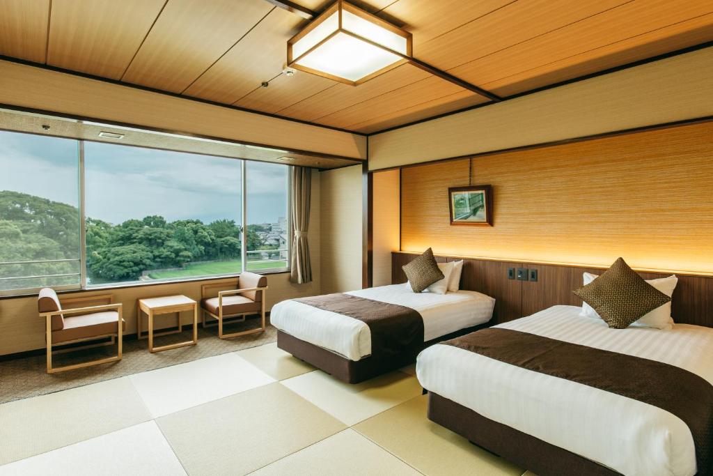 une chambre d'hôtel avec deux lits et une fenêtre dans l'établissement KAMENOI HOTEL Yanagawa, à Yanagawa