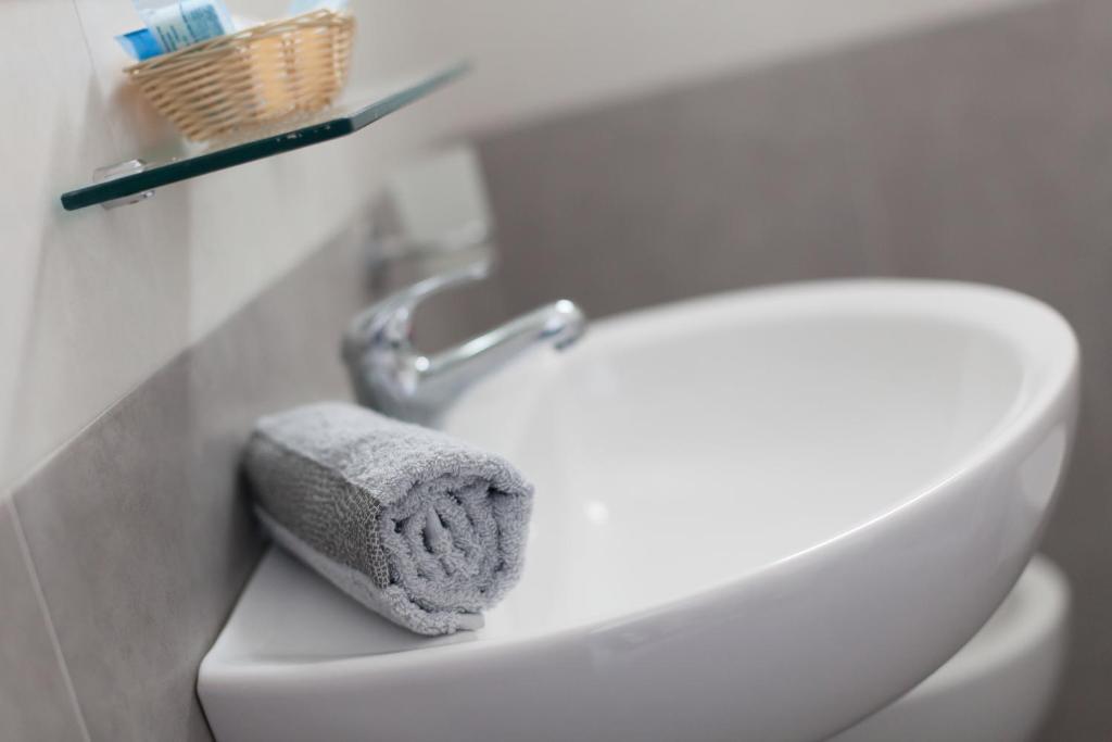 La salle de bains est pourvue de toilettes blanches et d'une serviette. dans l'établissement Hotel Platinum, à Rimini