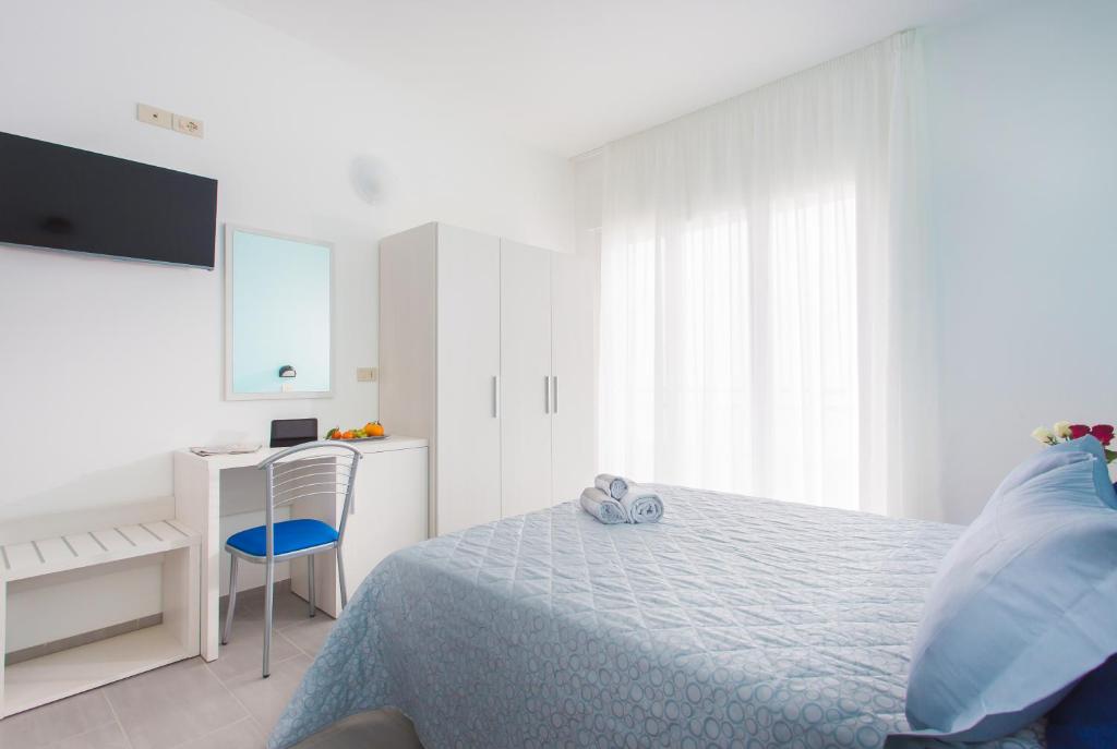 une chambre blanche avec un lit et un bureau dans l'établissement Hotel Platinum, à Rimini