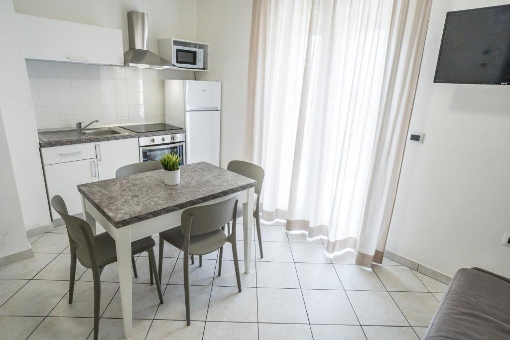 une cuisine avec une table et des chaises dans une pièce dans l'établissement Rimini Bay Suites&Residence, à Rimini