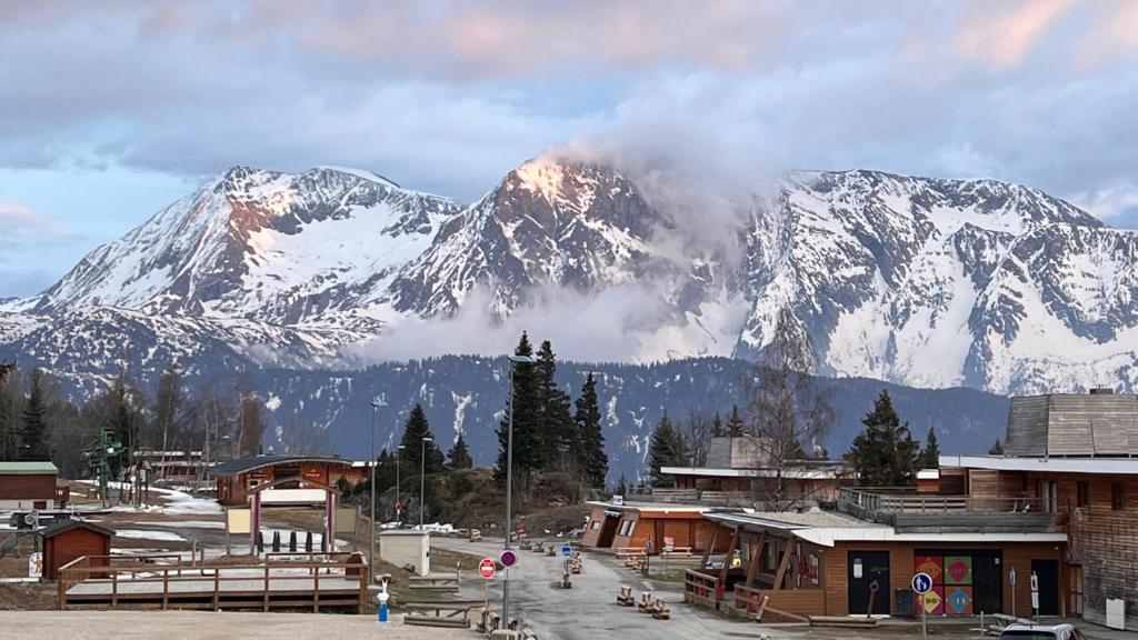 une montagne enneigée en face d'une station de ski dans l'établissement Appartement Chamrousse, à Chamrousse