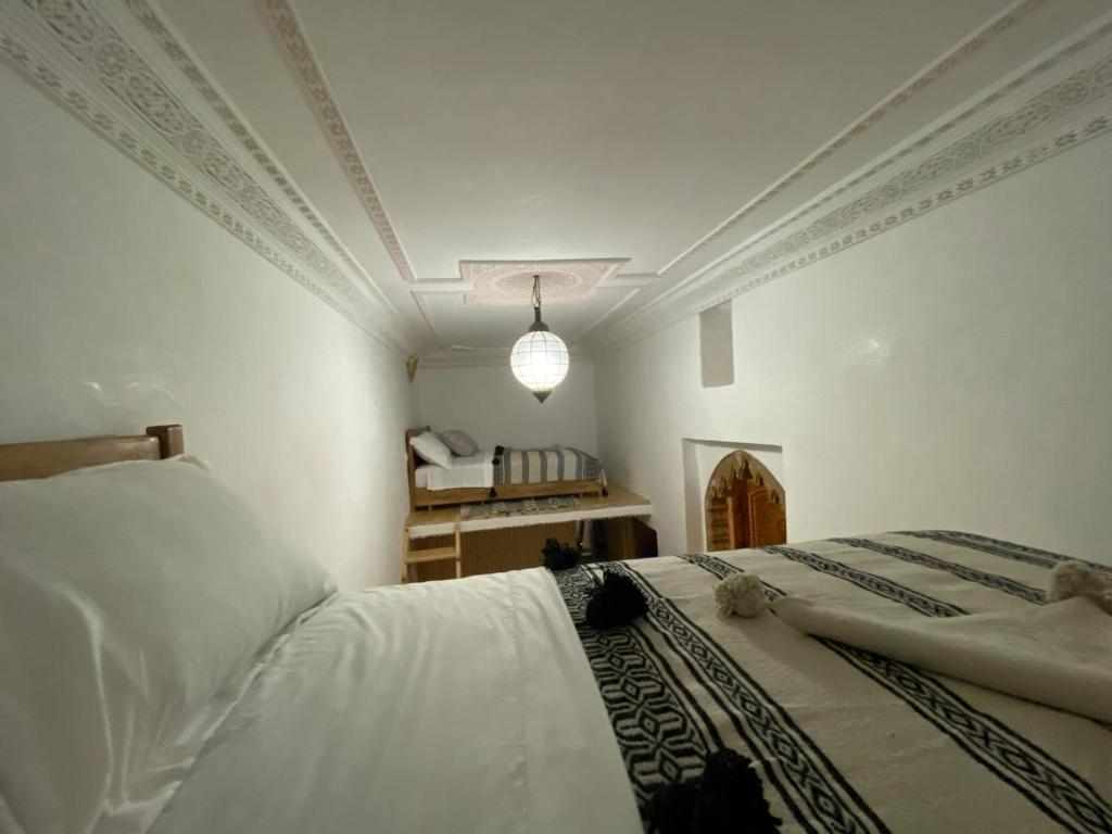 - une chambre avec un lit doté de draps blancs et d'un plafond dans l'établissement Hostel Capital, à Rabat