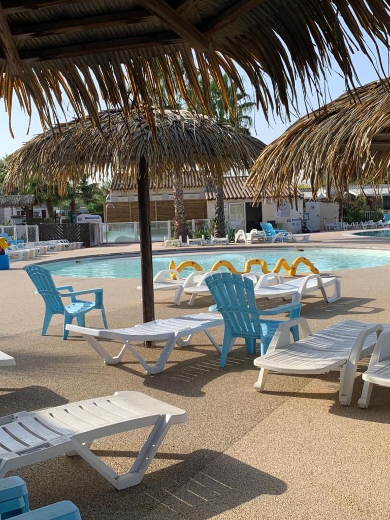 un groupe de chaises longues et une piscine dans l'établissement Little John, à Fréjus