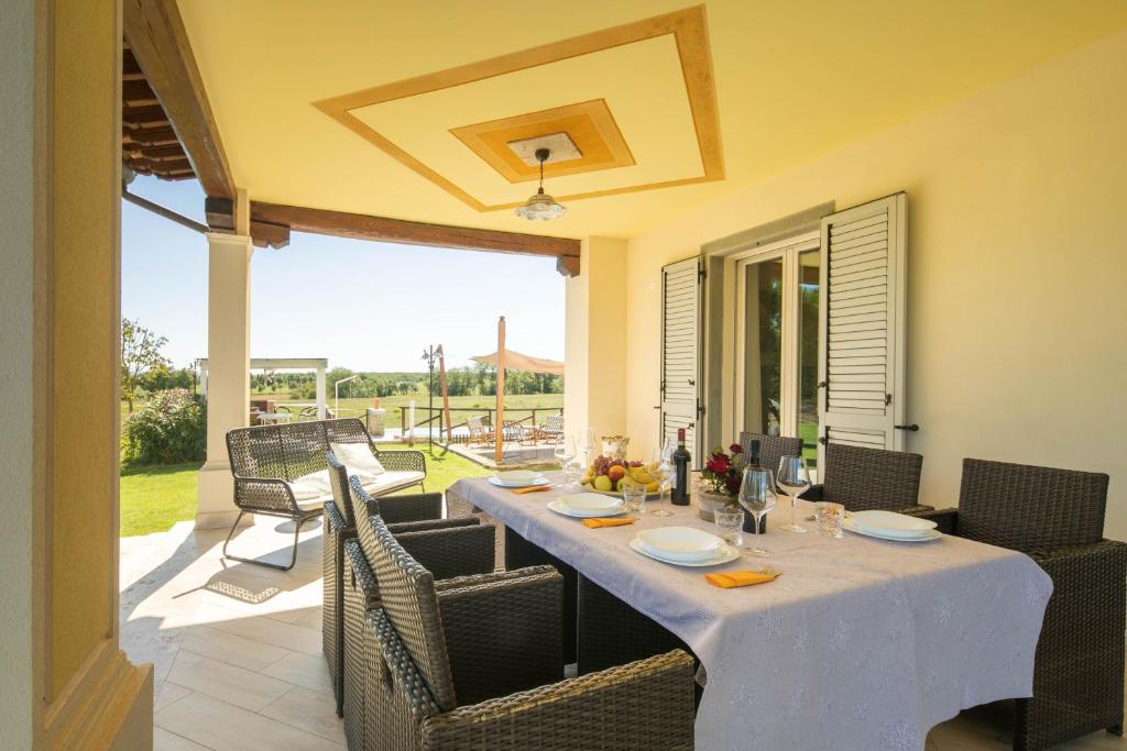 - une table avec des chaises et un chiffon de table blanc sur la terrasse dans l'établissement Casa Romano by VacaVilla, à Cortone
