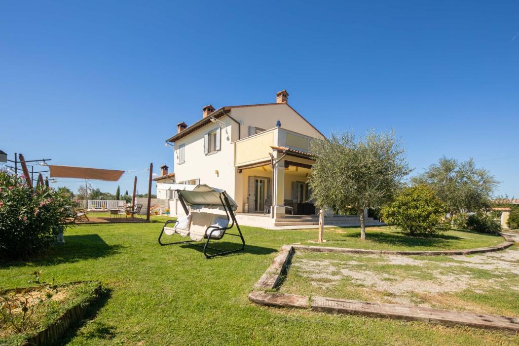 une maison avec une balançoire dans la cour dans l'établissement Casa Romano by VacaVilla, à Cortone