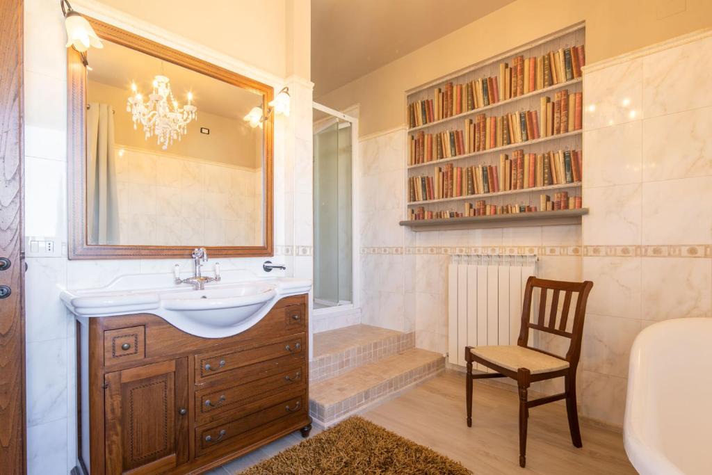 La salle de bains est pourvue d'un lavabo, d'une chaise et d'une baignoire. dans l'établissement Casa Romano by VacaVilla, à Cortone 31 autres photos