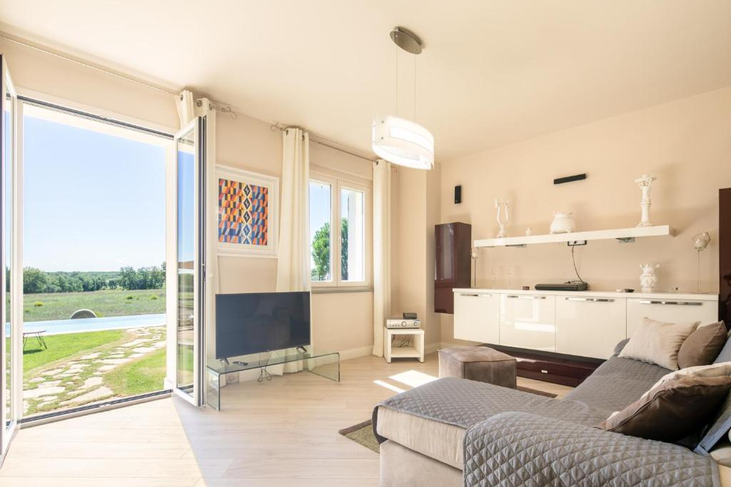 un salon avec un canapé et une télévision dans l'établissement Casa Romano by VacaVilla, à Cortone