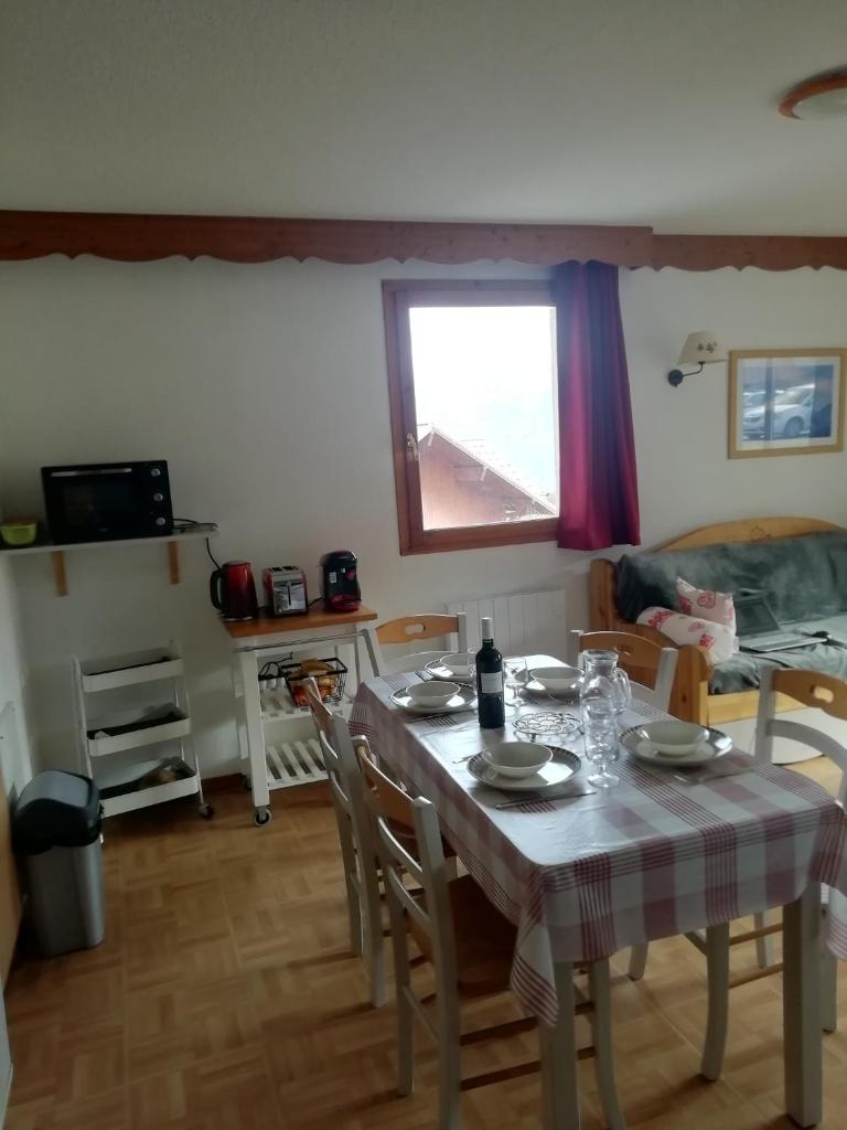- une salle à manger avec une table, des chaises et un lit dans l'établissement Espace et confort de 45 m2 dans station familiale à 1800, à Puy-Saint-Vincent