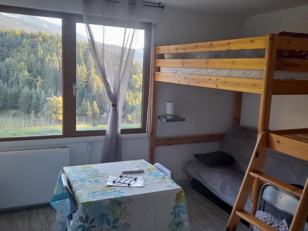 - une chambre avec des lits superposés, une table et une chaise dans l'établissement les glovettes Villard de lans, à Villard-de-Lans