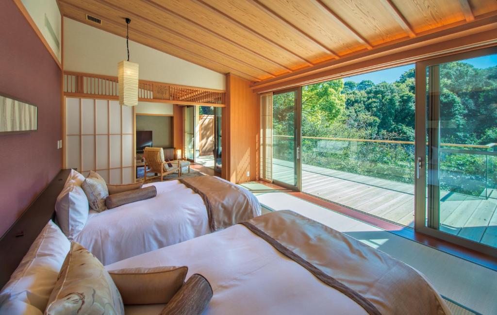 une chambre avec deux lits et une grande fenêtre dans l'établissement ABBA Resorts Izu - Zagyosoh, à Itō