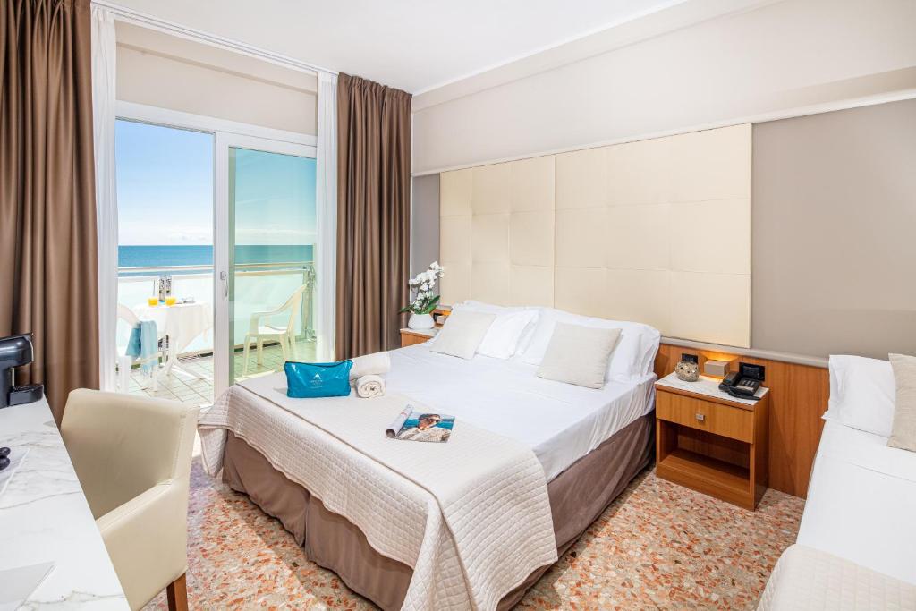 une chambre d'hôtel avec un lit avec vue sur l'océan dans l'établissement Hotel Royal, à Bibione