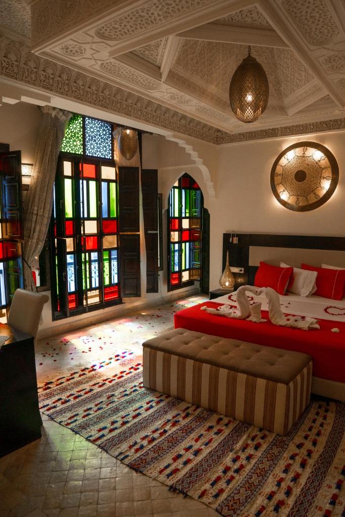 - une chambre avec un grand lit et des vitraux dans l'établissement Riad Tamarrakecht, à Marrakech