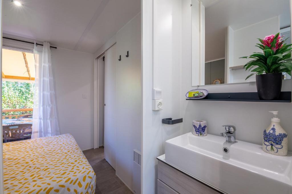 La salle de bains est pourvue d'un lavabo, d'un lit et d'une fenêtre. dans l'établissement Mobil home Queen Margaret, à Fréjus