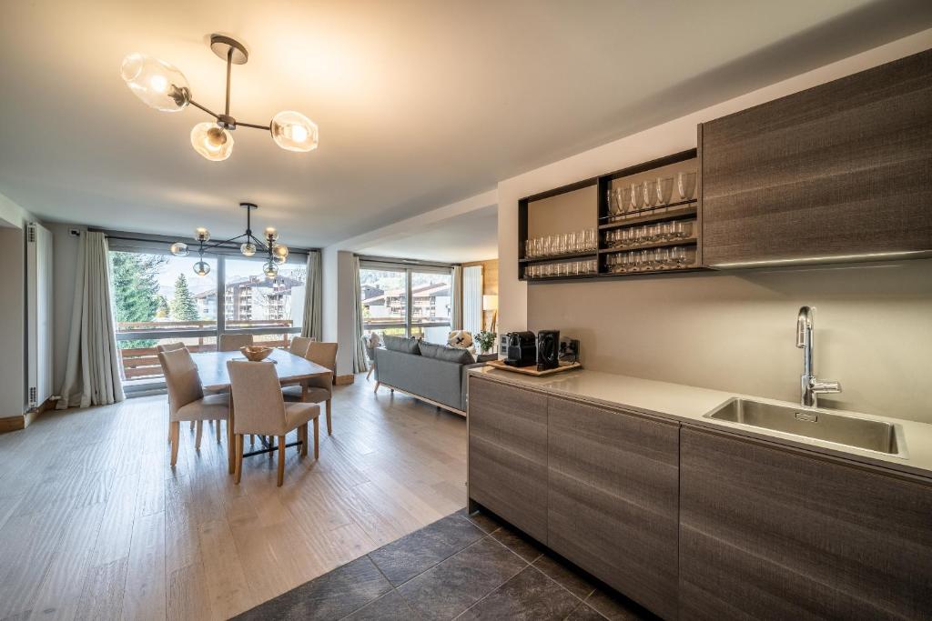 une cuisine avec une table et une salle à manger dans l'établissement Apartment Cortirion Megeve - by EMERALD STAY, à Megève 37 autres photos