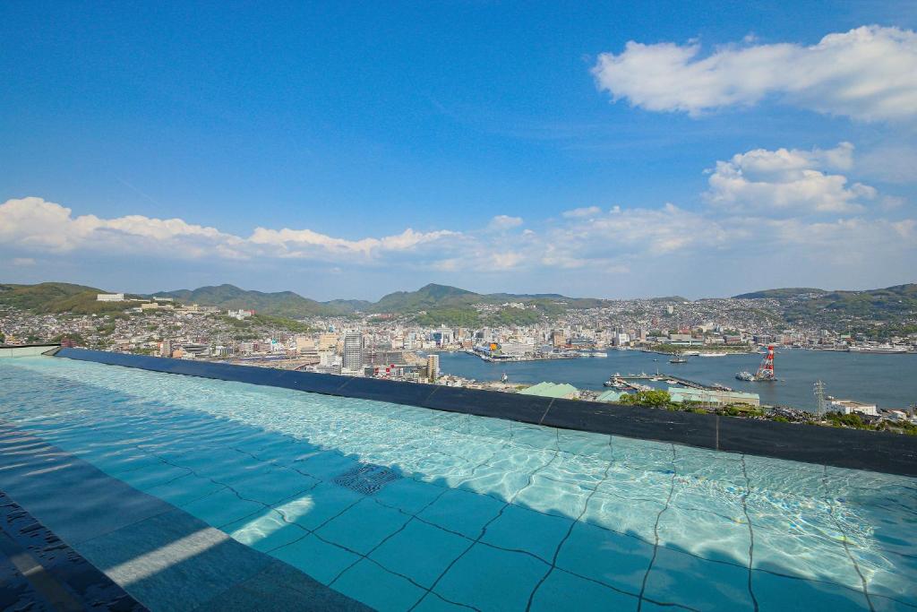 une grande piscine avec vue sur une ville dans l'établissement Ooedo Onsen Monogatari Nagasaki Hotel Seifu, à Nagasaki
