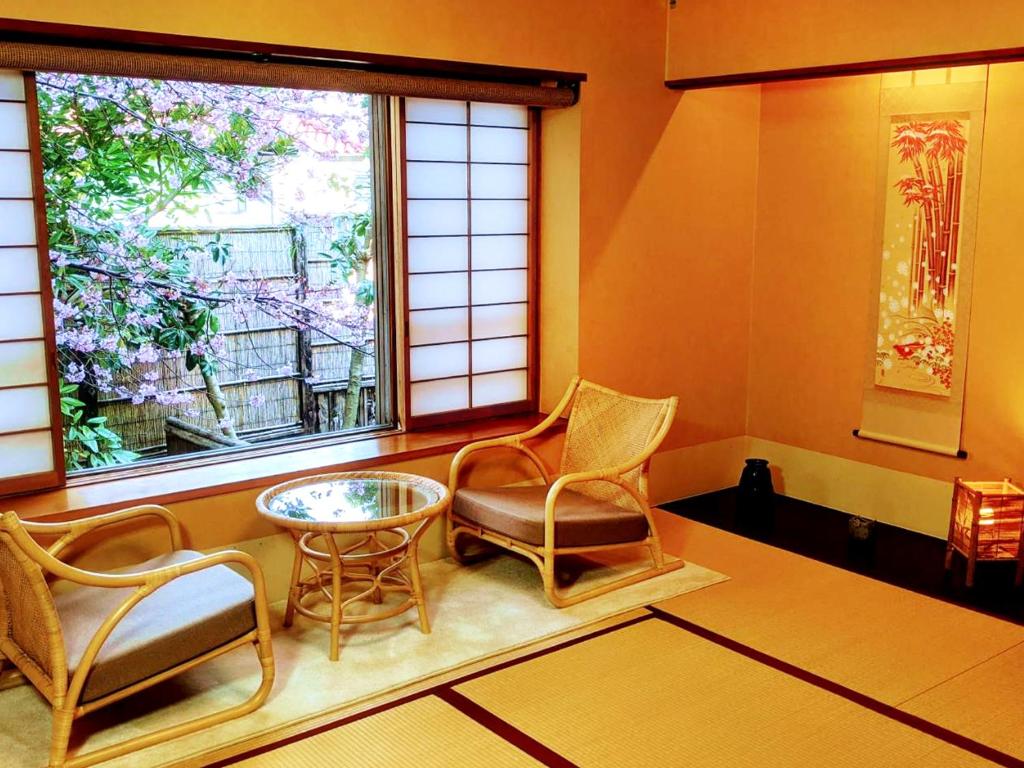 une chambre avec des chaises, une table et une fenêtre dans l'établissement Hanafubuki, à Itō 37 autres photos