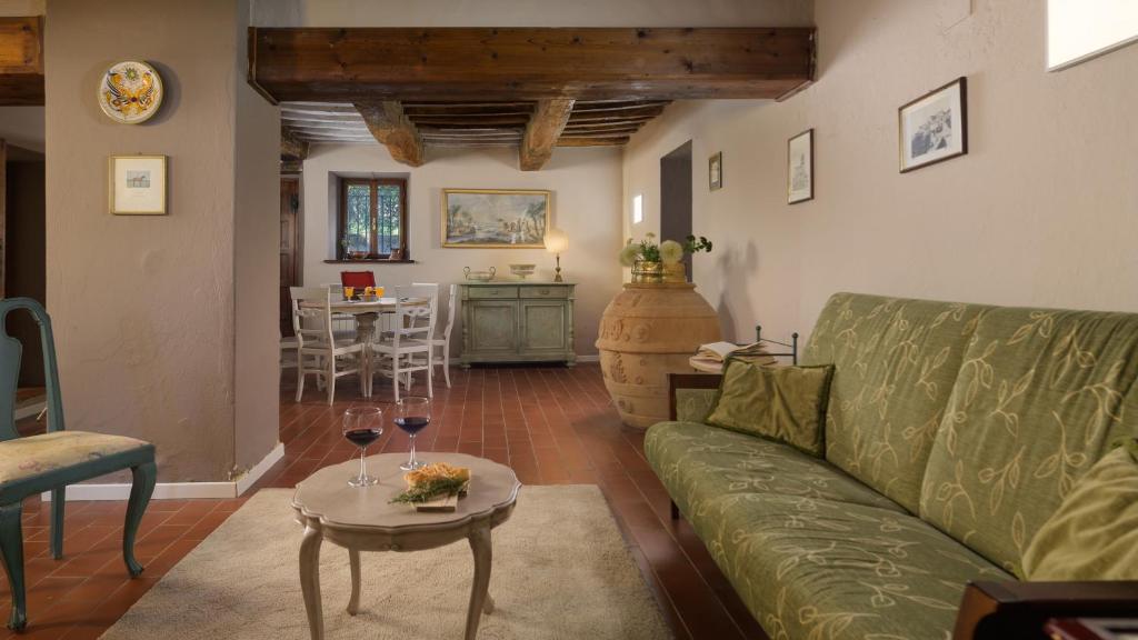 un salon avec un canapé vert et une table dans l'établissement CASALE IL TORCHIO 12&4, Emma Villas, à Ripabianca