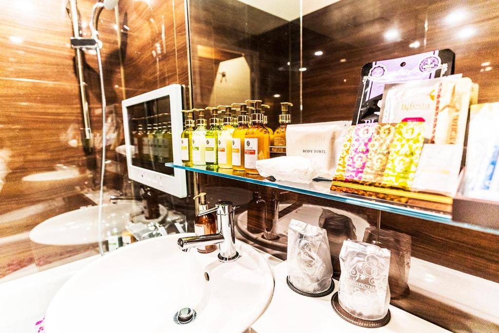 une salle de bain avec un lavabo et un miroir dans l'établissement Petit Bali Forest Shinjuku Sanchōme, à Tokyo 16 autres photos