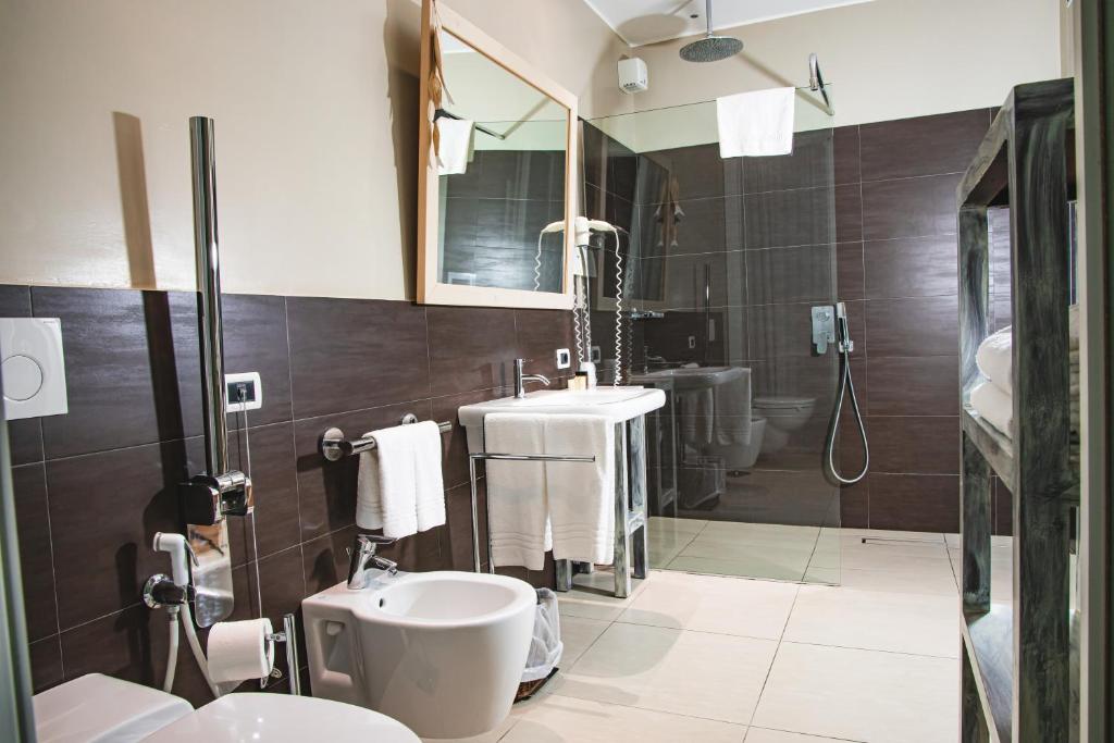 une salle de bain avec un lavabo, des toilettes et un miroir dans l'établissement Hotel Universal, à Senigallia 24 autres photos