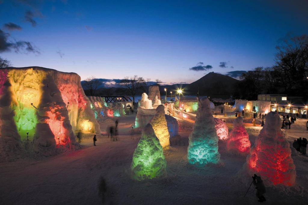 une exposition de lumières dans un parc la nuit dans l'établissement Shikotsuko Onsen Lake Side Villa SUIMEIKAKU-Adult Only, à Chitose
