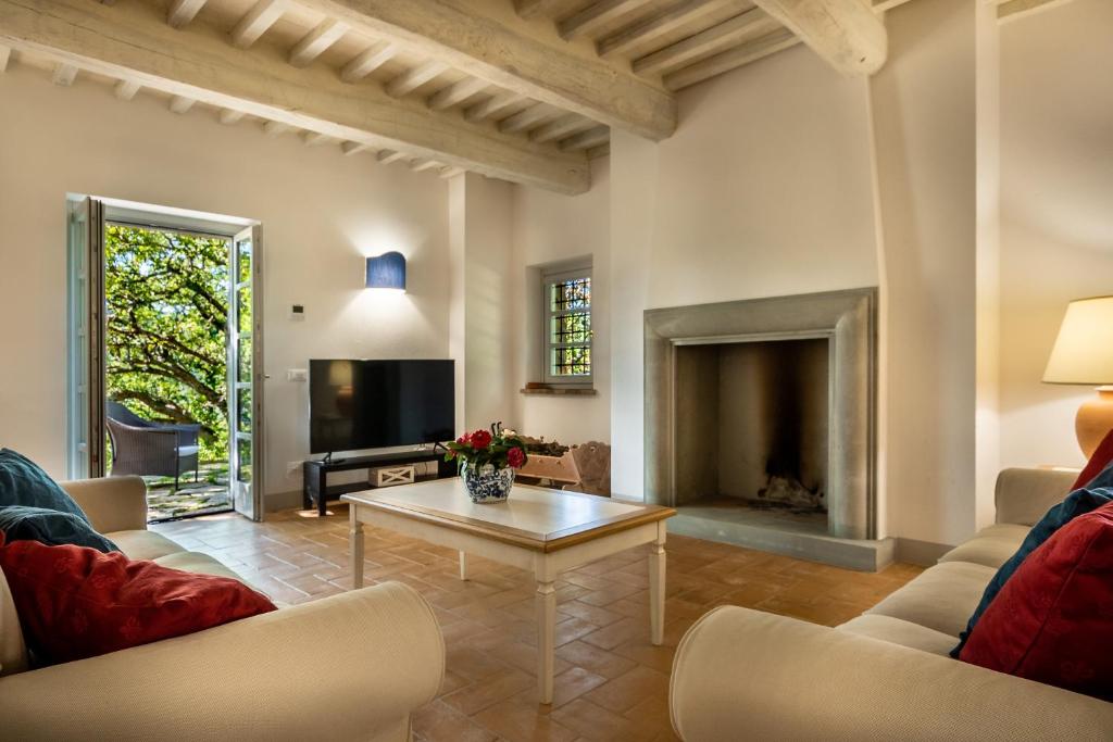 un salon avec une cheminée et une table dans l'établissement Villa Lucarella with pool, Air Con - San Casciano dei Bagni, à San Casciano dei Bagni