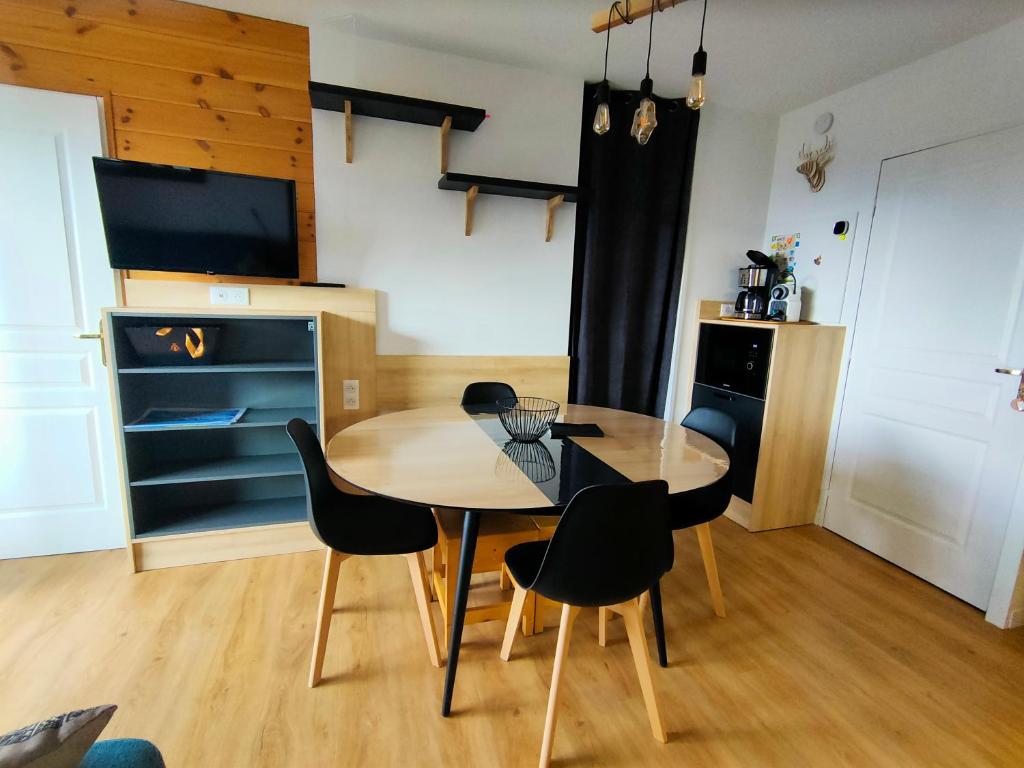 une salle à manger avec une table et des chaises dans l'établissement Risoul Appartement 2 chambres Piscine Balcons de Sirius, à Risoul