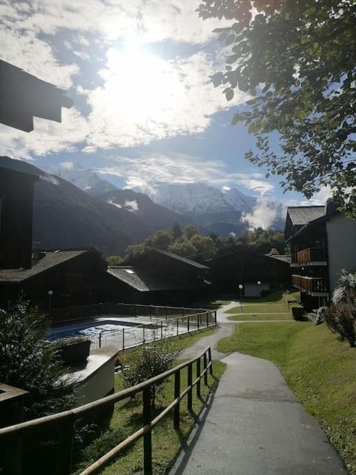 un chemin avec vue sur la rivière et les montagnes dans l'établissement Appartement aux pieds des pistes / piscine, à Saint-Gervais-les-Bains