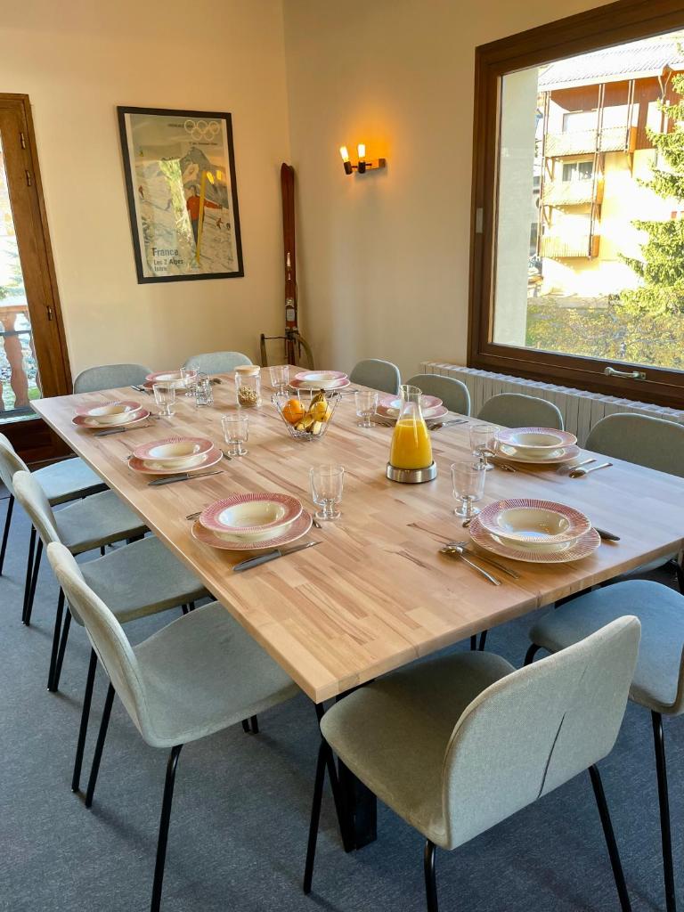 une grande table en bois avec des chaises et des assiettes. dans l'établissement Le Chalet, à Les Deux Alpes 34 autres photos