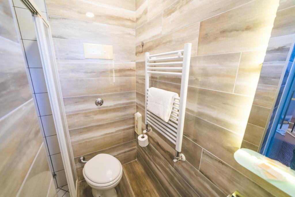 une petite salle de bain avec toilettes et lavabo dans l'établissement Hotel Grand Prix, à Sottomarina 88 autres photos