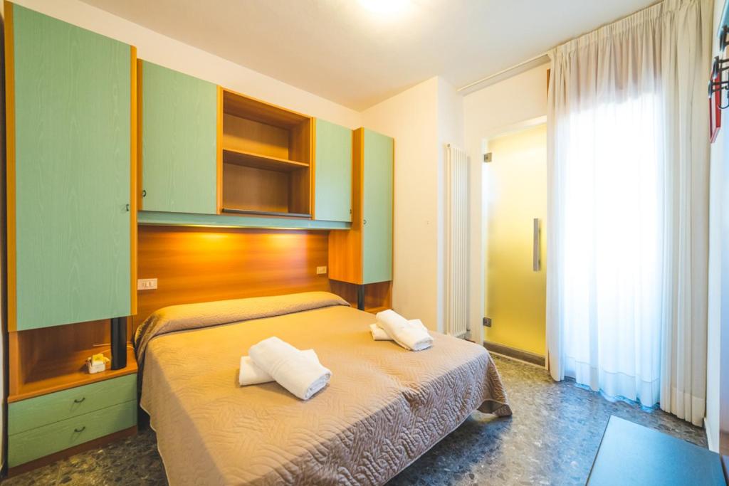 une chambre avec un lit avec deux oreillers dessus dans l'établissement Hotel Grand Prix, à Sottomarina