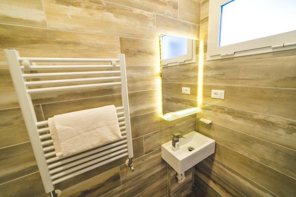 une salle de bain avec un lavabo et un miroir dans l'établissement Hotel Grand Prix, à Sottomarina