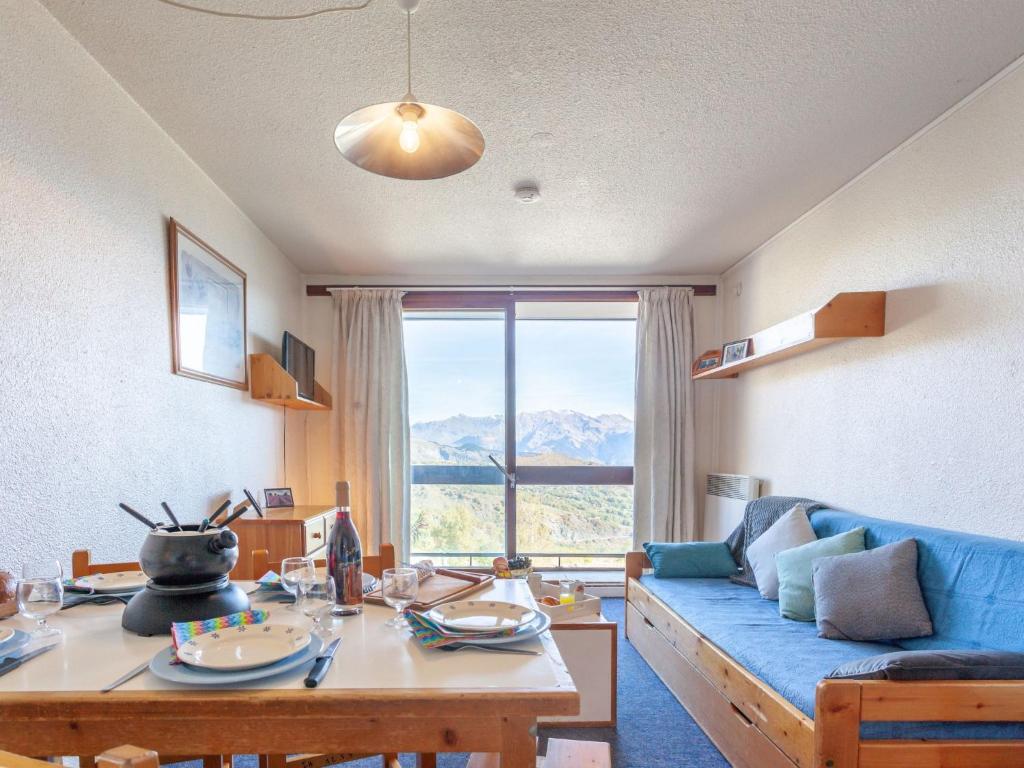 un salon avec un canapé bleu et une table dans l'établissement Apartment Pegase Phenix-10 by Interhome, au Corbier