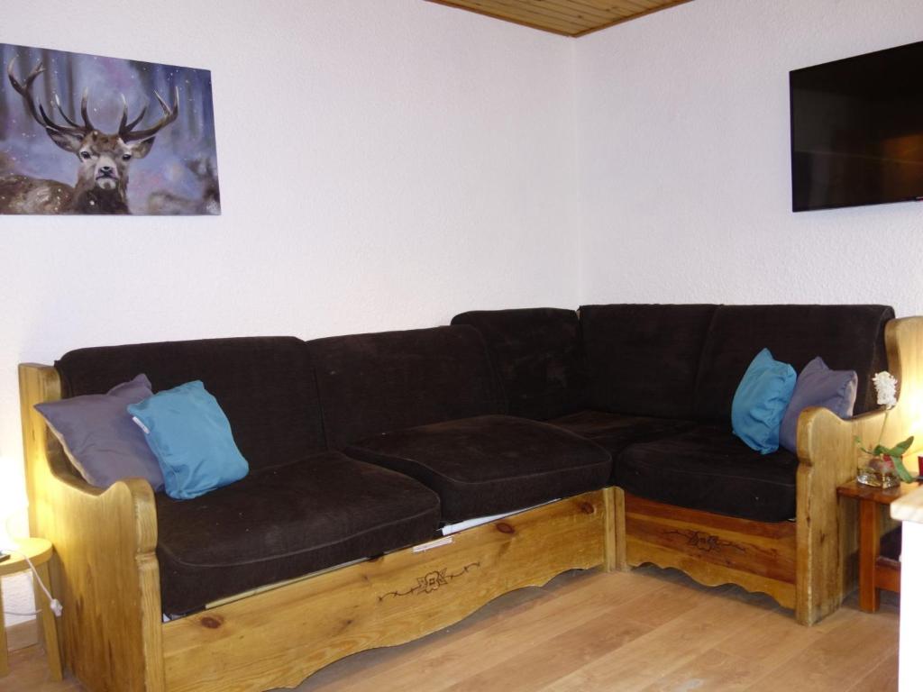 - un canapé noir avec des oreillers bleus dans le salon dans l'établissement Apartment Sérac A10 by Interhome, à Val Thorens