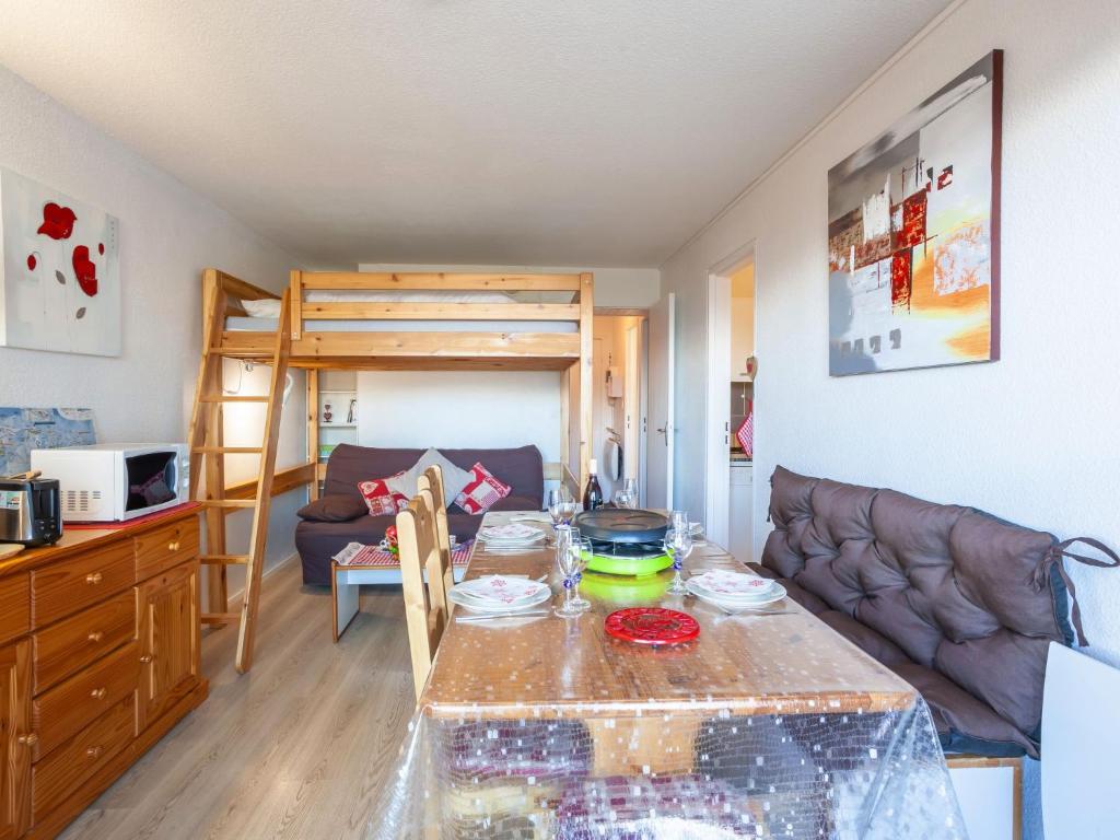 - un salon avec une table et des lits superposés dans l'établissement Apartment Pegase Phenix-70 by Interhome, au Corbier