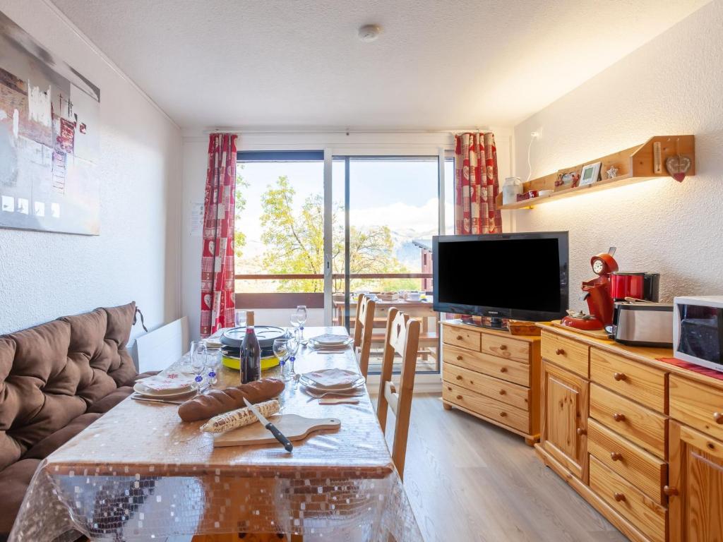 un salon avec une table et une télévision dans l'établissement Apartment Pegase Phenix-70 by Interhome, au Corbier 29 autres photos