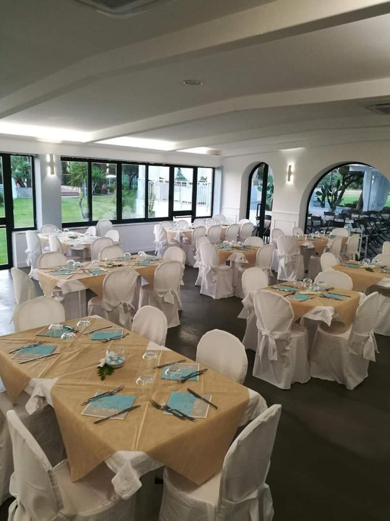 une salle de banquet avec des tables, des chaises blanches et un chercheur de table dans l'établissement Resort Sciabache, à Zambrone 45 autres photos
