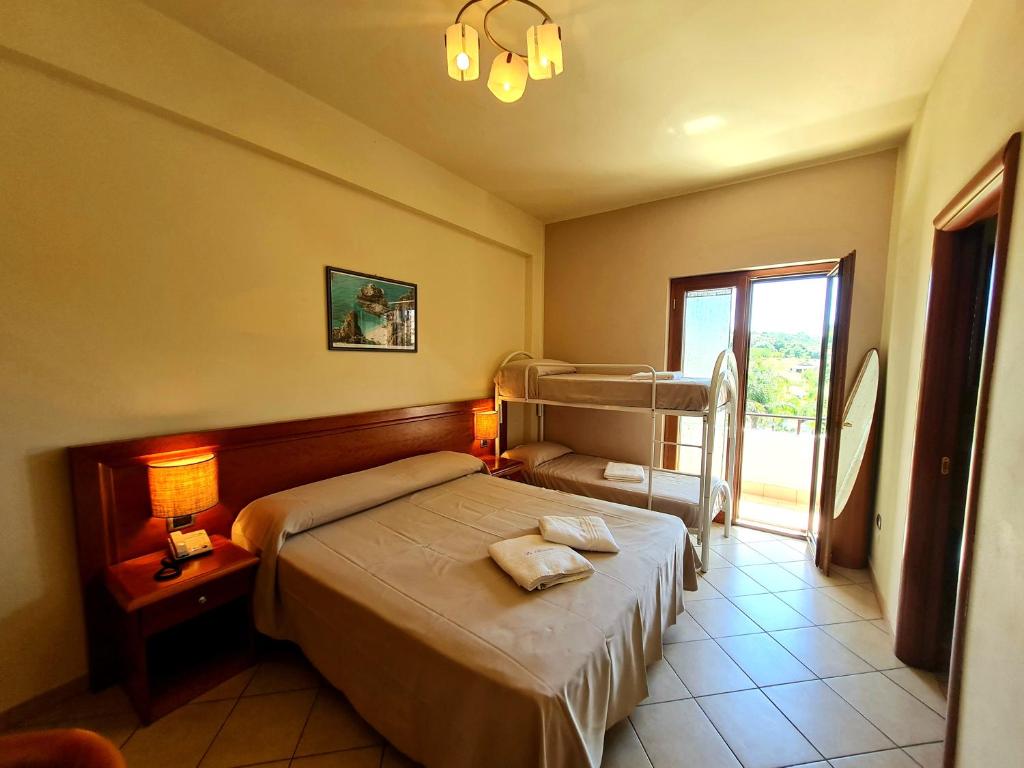 une chambre avec un lit et une fenêtre dans l'établissement La Bussola Hotel Calabria, à Capo Vaticano